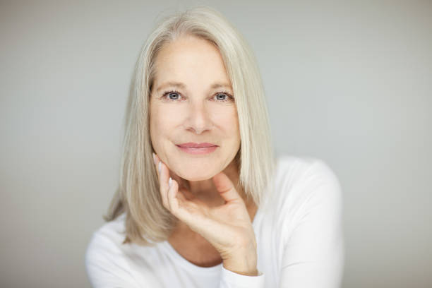 stunning beautiful and self confident best aged woman with grey hair stunning beautiful and self confident best aged woman with grey hair smiling into camera, portrait with white background mature beautiful woman stock pictures, royalty-free photos & images