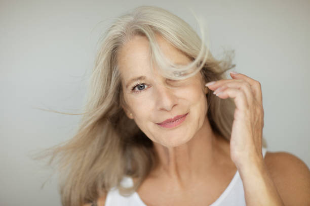 stunning beautiful and self confident best aged woman with grey hair stunning beautiful and self confident best aged woman with grey hair smiling into camera, portrait with white background mature beautiful woman stock pictures, royalty-free photos & images