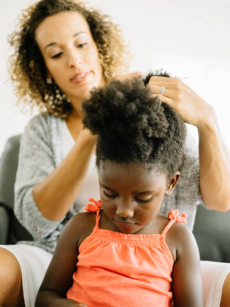 istock A Mother Doing Daughter's Hair 1012597432