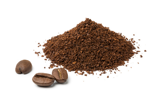 Heap of ground coffee and some beans isolated on white background
