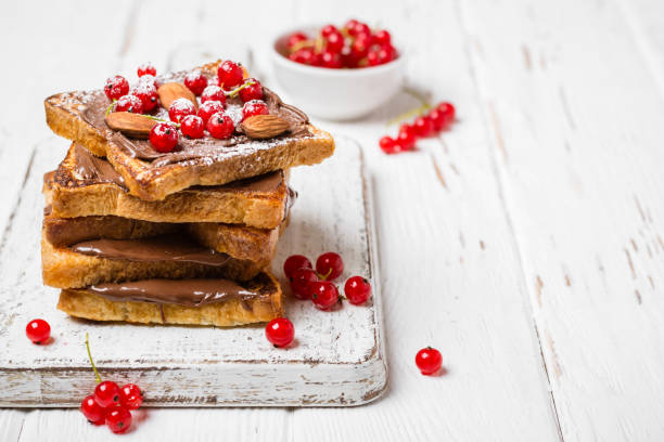 istock stack of fried toast with chocolate cream, red currant and almon 1012613458