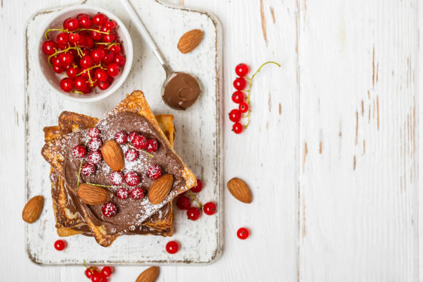istock stack of fried toast with chocolate cream, red currant and almon 1012613474