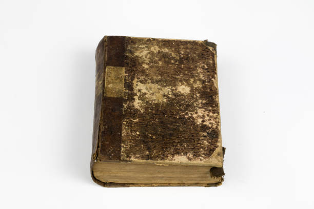 istock Old destroyed book on a white table. Old-style cover. White isolated background. 1012614308