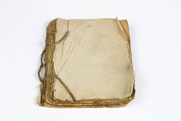 istock Old destroyed book on a white table. Old-style cover. White isolated background. 1012617470