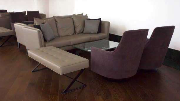 istock Business Interior. Brown parquet, beige leather sofas with cushions and a glass table 1012618034