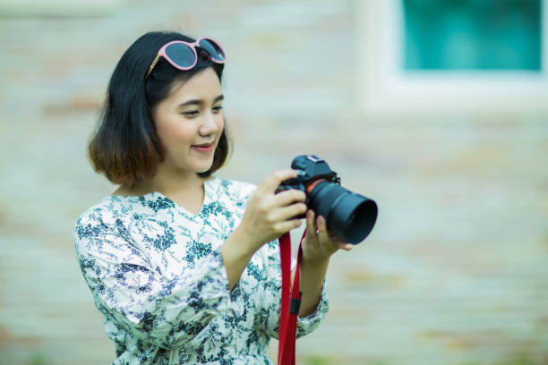istock Young asian woman checking photo from camera 1012619144