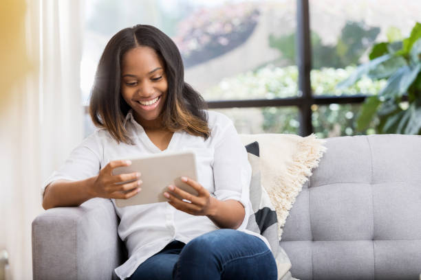 istock Young woman enjoys digital tablet game at home 1012627514