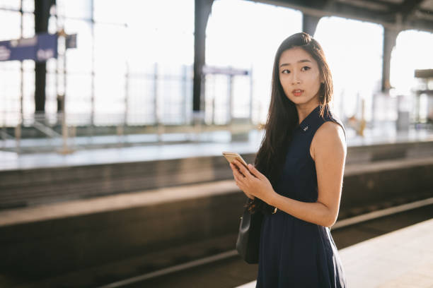 istock Woman checking her phone in train station. 1012628612