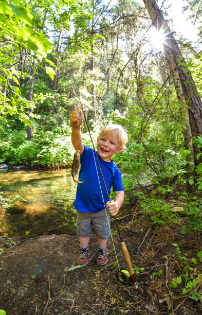 istock Fishing boy proudly holding trout 1012647562