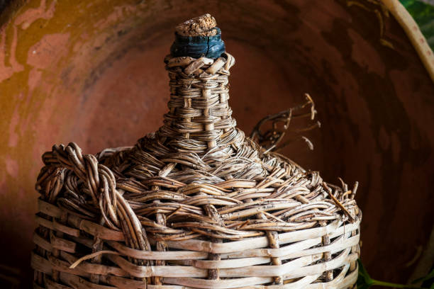 Old lined wicker carafe former used for home wine transport. Closeup