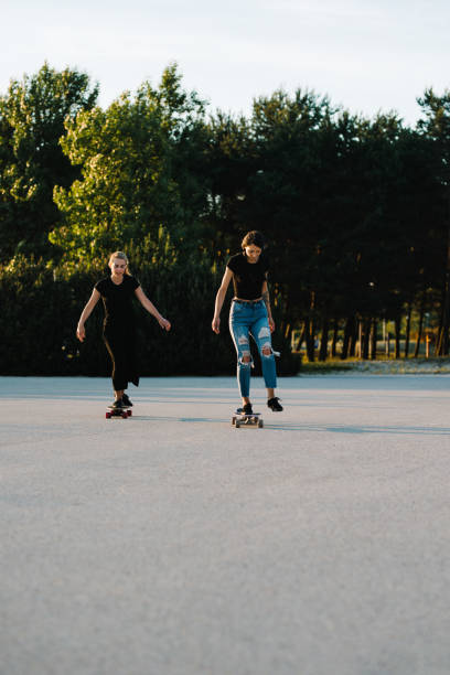 istock Two friends riding longboards 1012648460