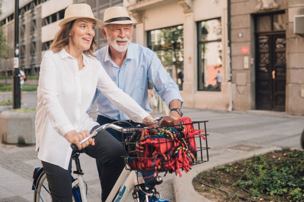istock Happy man helping woman ride a bicycle 1012676618