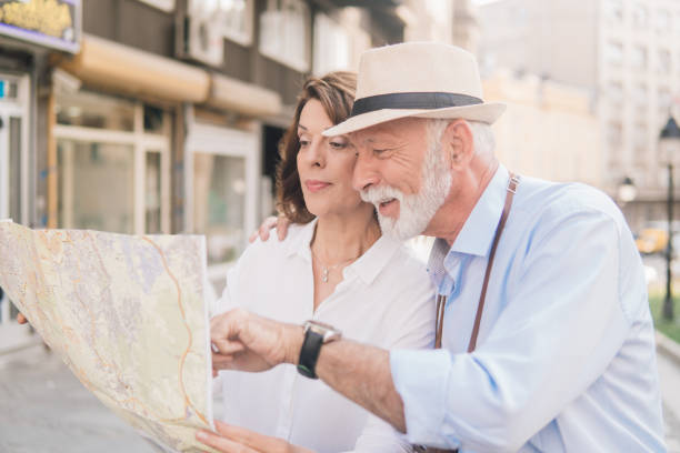 istock Elderly couple hugging and looking at the map 1012676692