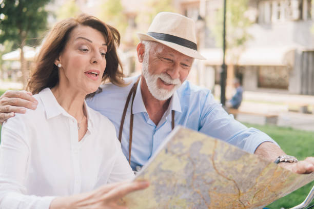 istock Happy older couple reading touristic map 1012676740