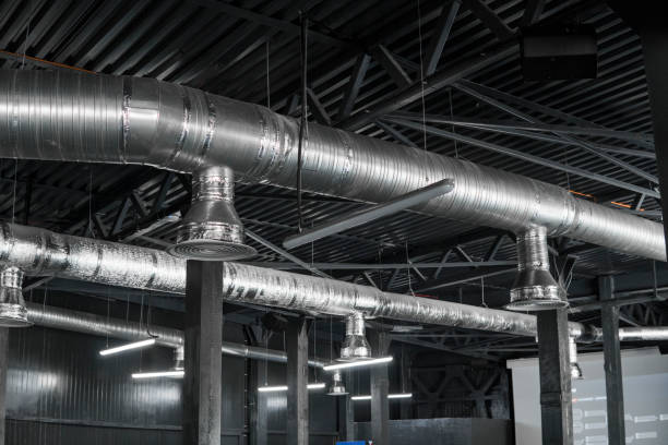 istock Ventilation system on the ceiling of large buildings. Ventilation pipes in silver insulation material hanging from the ceiling inside new building. 1012679300
