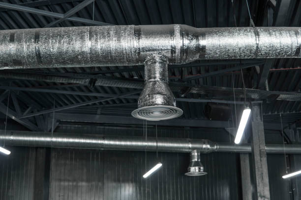 istock Ventilation system on the ceiling of large buildings. Ventilation pipes in silver insulation material hanging from the ceiling inside new building. 1012679330