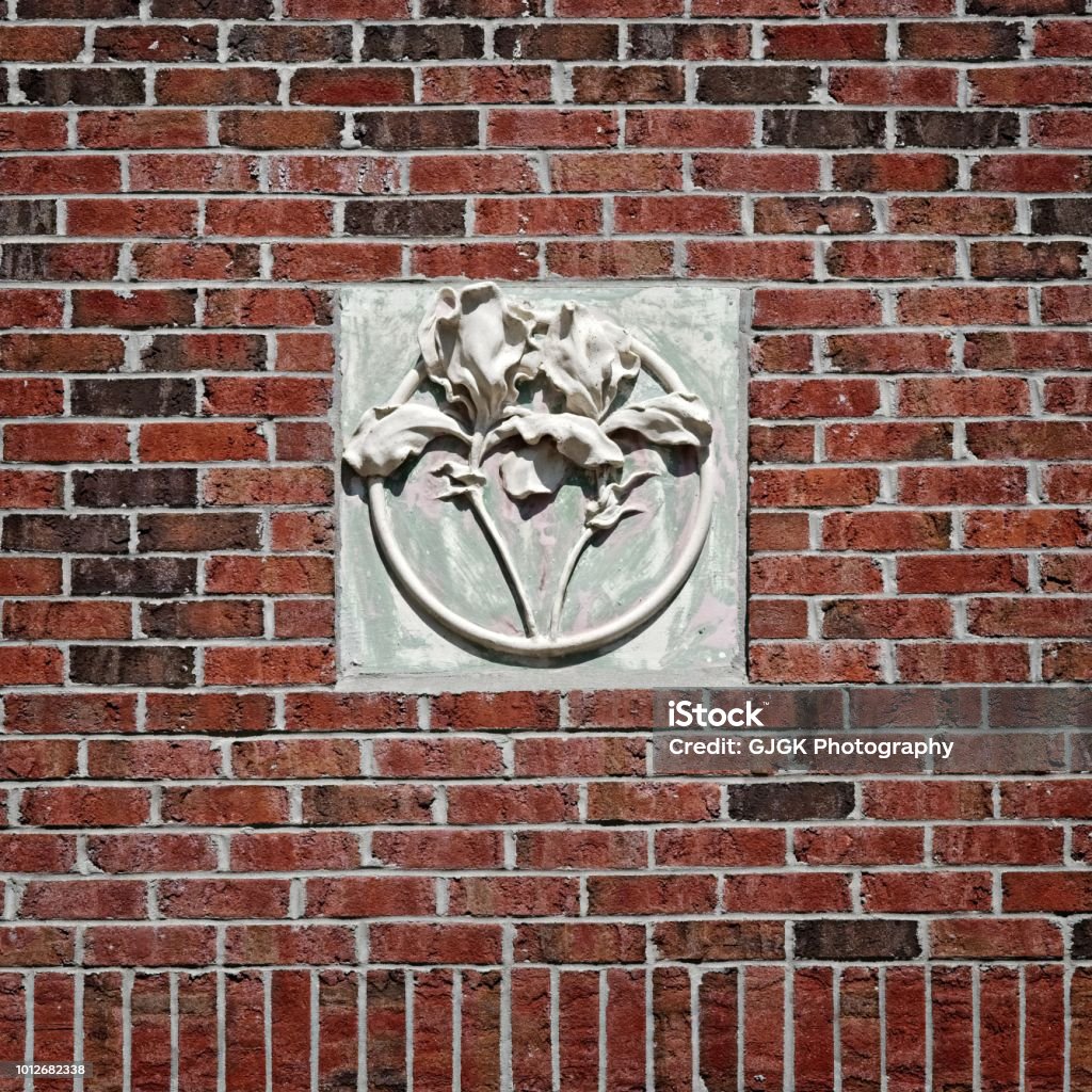 Concrete Flower on Red Brick Wall New Orleans, LA USA - May 9, 2018  -  Concrete Flower on Red Brick Wall Tulane University Abstract Stock Photo