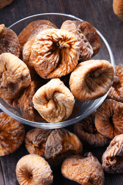 istock Composition with bowl of dried figs on wooden table 1012687974
