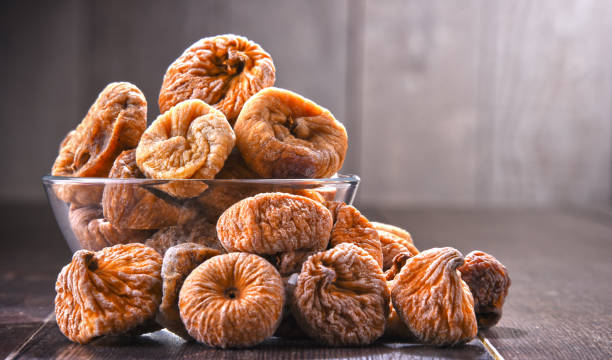 istock Composition with bowl of dried figs on wooden table 1012688006