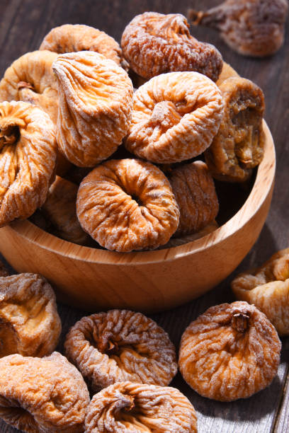 istock Composition with bowl of dried figs on wooden table 1012688034
