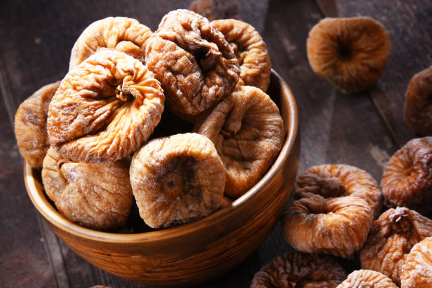 istock Composition with bowl of dried figs on wooden table 1012688058
