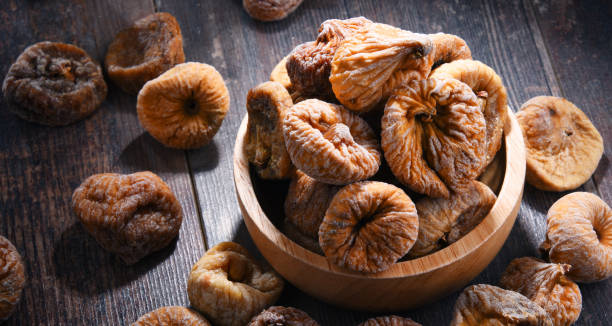 istock Composition with bowl of dried figs on wooden table 1012688100