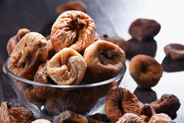 istock Composition with bowl of dried figs on wooden table 1012688108