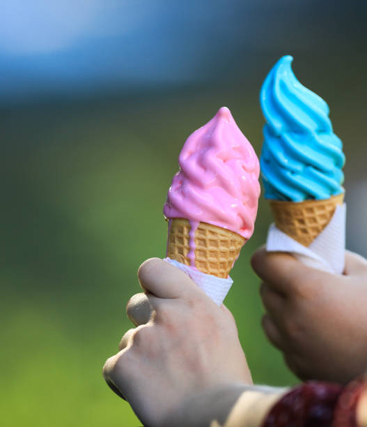 istock pink and blue ice cream in the hands 1012690924