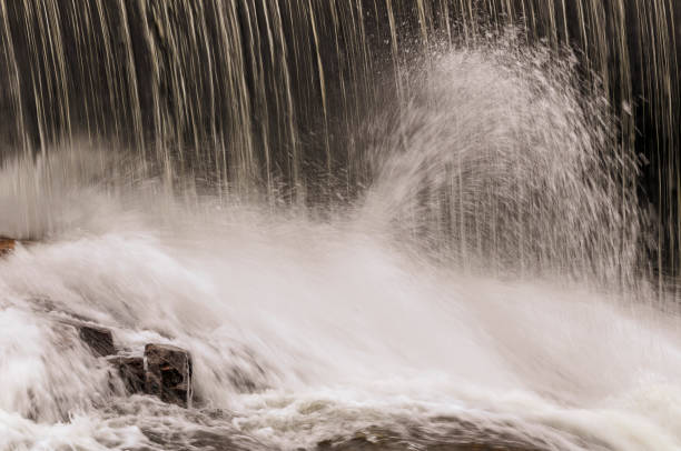 istock Smooth water off dam smashes into rocks below 1012695554