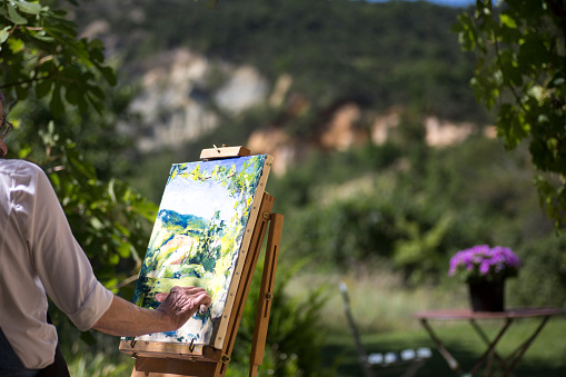 Active senior woman painting en plein air