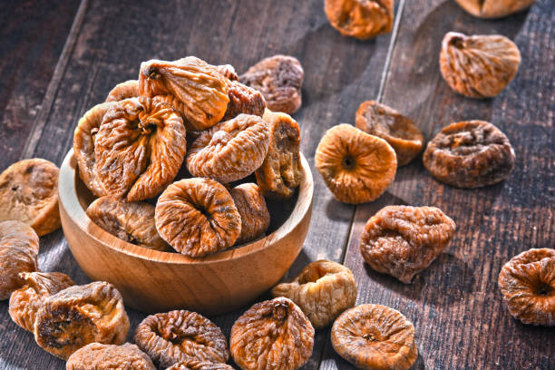 istock Composition with bowl of dried figs on wooden table 1012702176