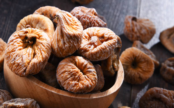 istock Composition with bowl of dried figs on wooden table 1012702204