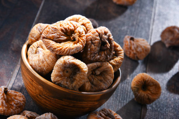 istock Composition with bowl of dried figs on wooden table 1012702224