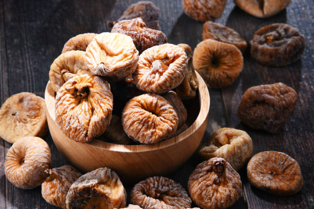 istock Composition with bowl of dried figs on wooden table 1012702250