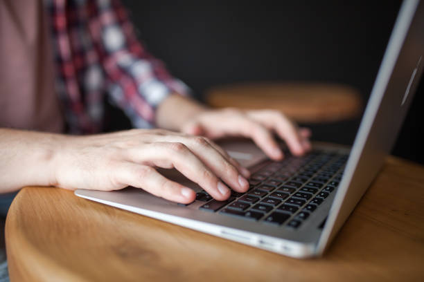 istock Man hands typing on a laptop keyboard on a desk 1012738234