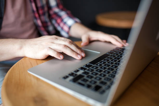 istock Man hands typing on a laptop keyboard on a desk 1012740500