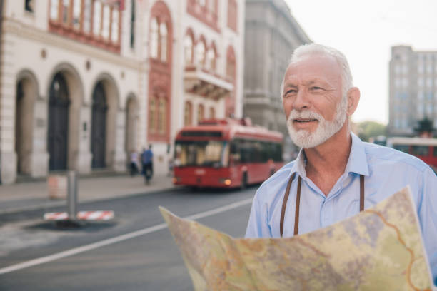 istock Joyful senior man with touristic map 1012741336