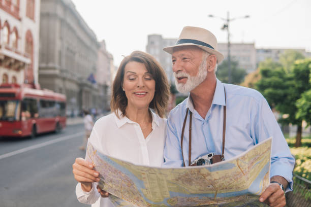 istock Smiling married couple holding touristic map 1012749538