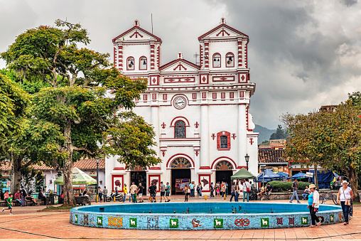 Guatape, Colombia - March 27, 2018: People in front of Colorful Catholic church 