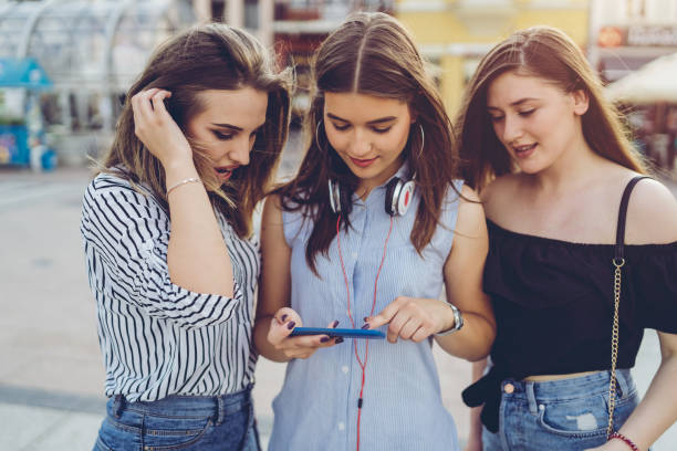 istock Three friends looking at phone content together 1012760604