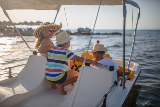 mutter mit zwei söhnen auf einem tretboot - pedal boat stock-fotos und bilder