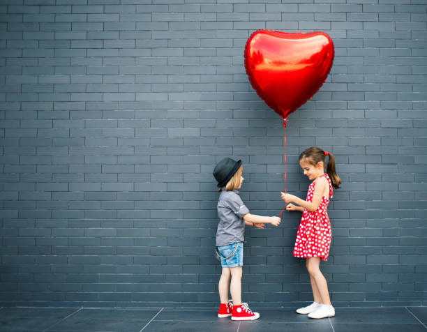 globo de aire de dos niños con forma de corazón - child balloon happiness cheerful fotografías e imágenes de stock