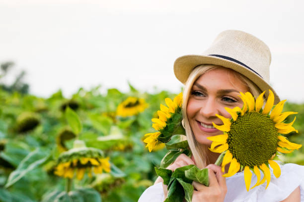 istock Woman With Hat Holding Sunflowers 1012776252