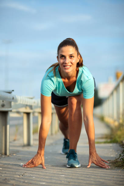 istock Determined young woman in sprint starting position, ready for running 1012783820