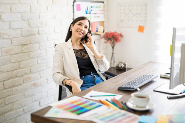istock Female designer talking with client over phone 1012791186