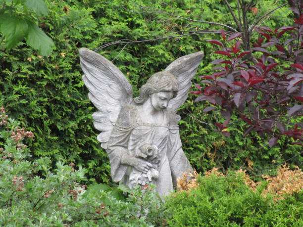 cement reproduction angel amid green garden foliage