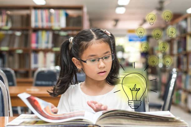 istock Innovative creative idea for copyrights law concept with kid surprised reading book with lightbulb in library 1012801996