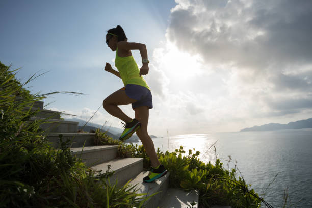 istock Determined woman running up on seaside mountain stairs 1012838462