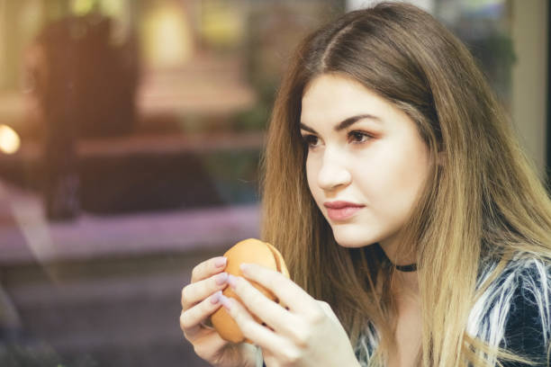 istock Young woman with tasty hamburger. Close up. 1012887006