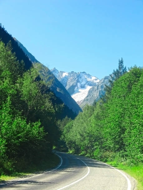 istock Road leads to caucasus mountains. Summer and snow 1012892502